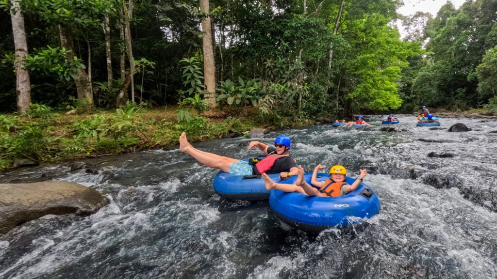 Parents and their kids enjoying rapids in tubing rio celeste