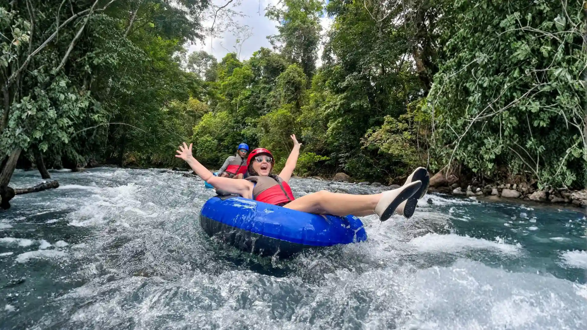 Tubing Rio Celeste: guests floating down the turquoise river through the Costa Rica rainforest