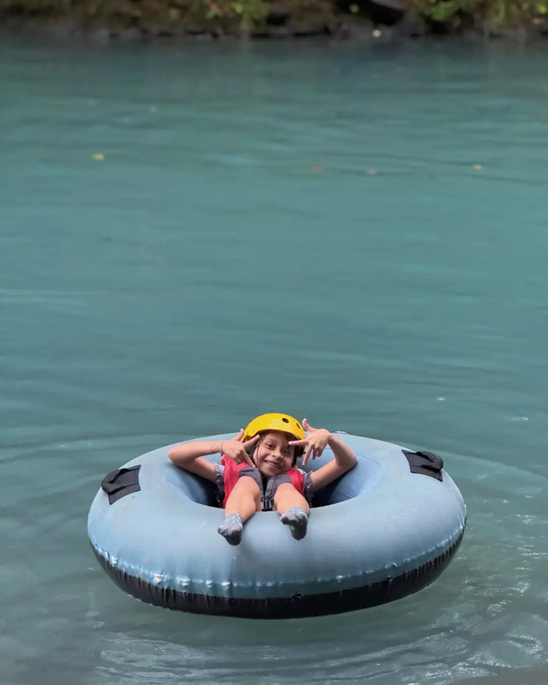Rio Celeste tubing with kids on calm turquoise water