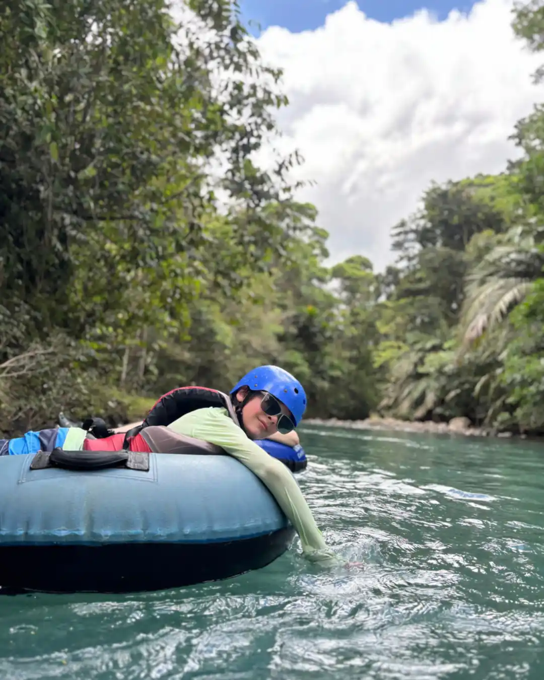Guests floating through gentle rapids on the Rio Celeste