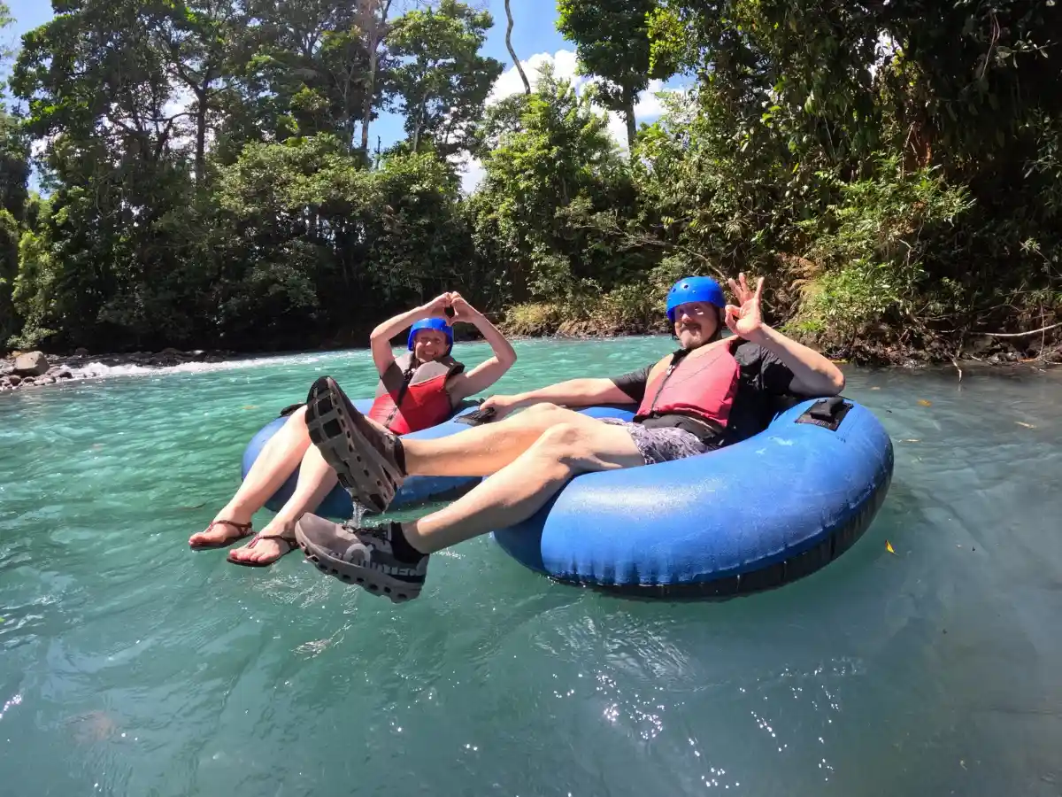 Adults relaxing on tubes on the turquoise Rio Celeste during a guided tubing tour