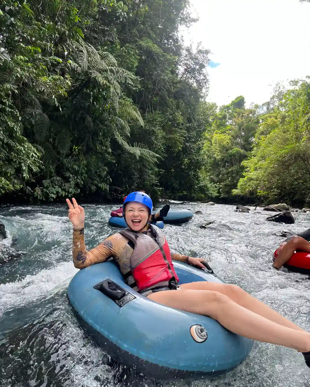 Traveler enjoying tubing on the turquoise Rio Celeste river
